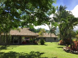 ein Haus mit einem großen Garten mit Palmen in der Unterkunft Lagoon Breeze Villas in Rarotonga