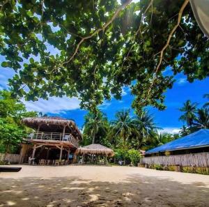 un complejo con un gran edificio con techo en Sabas Beach and Campsite, en Siquijor