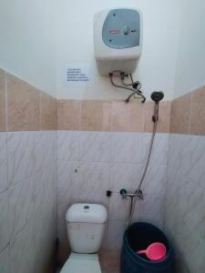 a small bathroom with a toilet and a camera at Villa Highland No 9 Berastagi View in Berastagi +20 photos