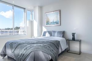 a white bedroom with a bed and a large window at Atico Puerto Sol in Altea