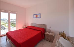 a bedroom with a red bed and a window at Gorgeous Apartment In Nicotera Marina in Nicotera Marina