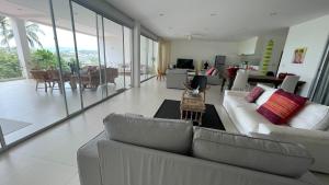 a living room with two couches and a dining room at Kata Top Villas in Kata Beach