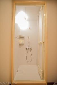 y baño con ducha y puerta de cristal. en Guest House Moshiripa en Wakkanai