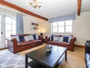 a living room with leather couches and a coffee table at Hunters Moon in Tenbury