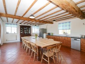 a large kitchen with a wooden table and chairs at Hunters Moon in Tenbury