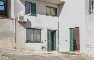 PortigliolaにあるLovely Apartment In Portigliola With House A Mountain Viewの緑のドアと窓のある白い建物