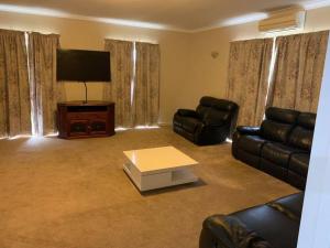 ein Wohnzimmer mit Sofas und einem Flachbild-TV in der Unterkunft Joe’s holiday home in Albany