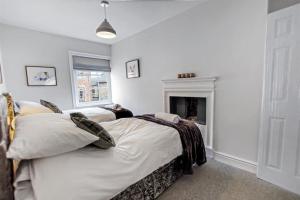 1 dormitorio con 2 camas y chimenea en Comfy Dales holiday base on Market Place of historic market town, en Richmond