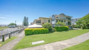 a house with a lawn in front of it at Yamba Beach Motel in Yamba