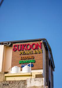 a sign on the side of a pearl int loading loadingondangering at Sukoon Pearl inn in Jabalpur