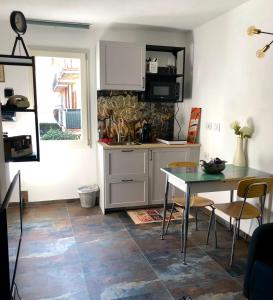a kitchen with a table and a sink and a counter at Gattaglio 22 Guest House in Reggio Emilia