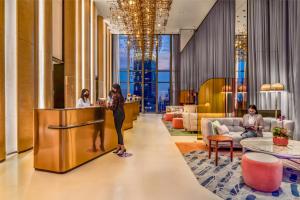 a woman standing at a counter in a hotel lobby at Capri by Fraser, Bukit Bintang in Kuala Lumpur