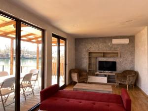 a living room with a red couch and a tv at Lake River House Ada Bojana in Ulcinj