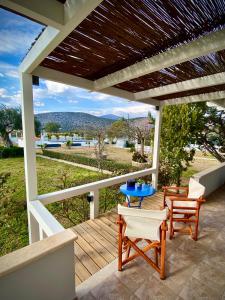 een terras met een tafel en stoelen bij Villa Hylas Luxury Bed & Breakfast Kilada in Kilada