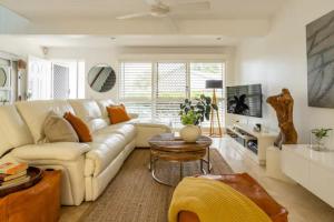 sala de estar con sofá blanco y mesa en Ocean Sounds, en Peregian Beach