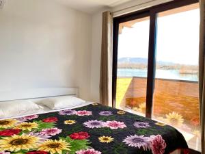 een slaapkamer met een bed en een groot raam bij Lake River House Ada Bojana in Ulcinj