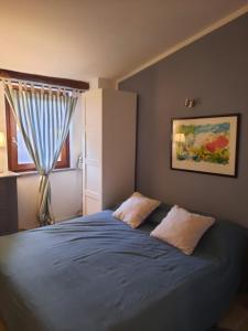 a bedroom with a blue bed with a window at Casa Bella Vista Trevignano Romano in Trevignano Romano