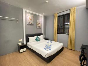 a bedroom with a bed with a table in it at Rae Hotel Bukit Bintang in Kuala Lumpur