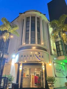 a hotelire building with palm trees in front of it at Rae Hotel Bukit Bintang in Kuala Lumpur