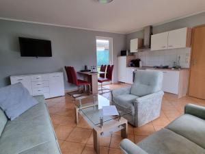 a living room with a couch and chairs and a table at Terraced house im Natur- und Ferienpark am Groß Labenzer See, Klein Labenz in Klein Labenz