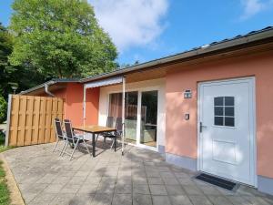 un patio con mesa y sillas frente a una casa en Terraced house in the nature and holiday park on the Groß Labenzer See, Klein Labenz, en Klein Labenz