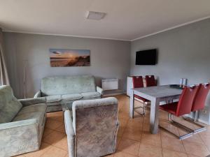 a living room with a couch and a table and chairs at Terraced house in the nature and holiday park on the Groß Labenzer See, Klein Labenz in Klein Labenz