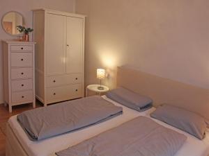 um quarto com 2 camas e uma cómoda com um candeeiro em Ferienhaus Nr 30, Kategorie Komfort Plus, Feriendorf Hochbergle, Allgäu em Bichel