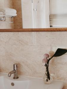 a bathroom sink with a vase with flowers in it at Artvilla Village in Xihu