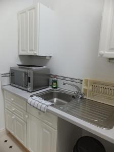 uma cozinha com um lavatório e um micro-ondas em Grove Guest House em Nottingham