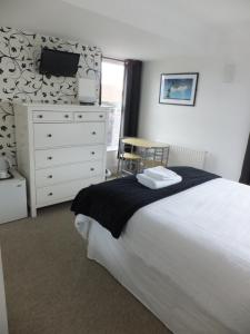 a bedroom with a bed and a dresser with a tv at Grove Guest House in Nottingham