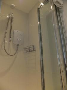 een douche met een glazen deur in de badkamer bij Grove Guest House in Nottingham