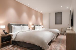 Postel nebo postele na pokoji v ubytování Phoenix Hotel Taichung