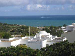a white building with the ocean in the background at Torre Velha AL in Albufeira