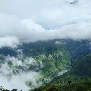 uma vista aérea de uma montanha com nuvens em Pema lhamu homestay em Darjeeling