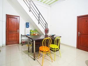 a dining room with a table and yellow chairs at OYO Life 90587 Domen Homestay Syariah in Krui