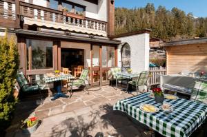 a patio with tables and chairs on a house at Hotel Effland -Sauna -Pool in Bayrischzell