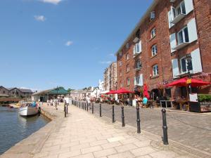 een kanaal met gebouwen en tafels en een boot op het water bij Orchard View Lodge in Exeter