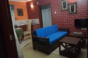 a blue couch in a room with a brick wall at Parachichi House BNB in Arusha