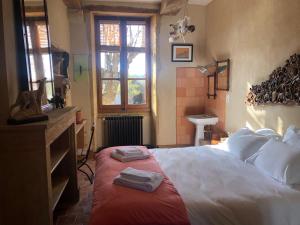 a bedroom with a bed with two towels on it at Les Jardins des Soussilanges in Céron