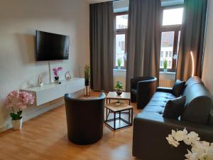 a living room with a couch and a tv at SALZHAUSBLICK FAMILY APARTMENTS - Zentrale Lage am Salzhaus - MwSt-Rechnung verfügbar in Zittau