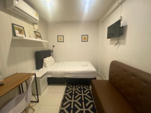 a small room with two beds and a couch at The Urban Age DeLuxe in Bangkok
