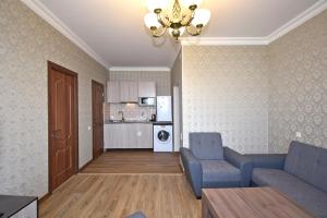 a living room with two blue chairs and a kitchen at Apartment for guest A2 in Yerevan