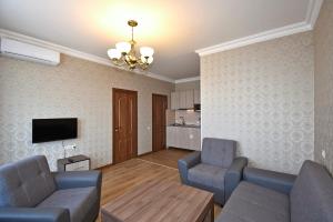 a living room with two chairs and a couch and a tv at Apartment for guest A2 in Yerevan