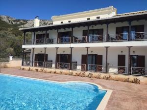 a villa with a swimming pool in front of a building at Guesthouse Michobeis in Kamarína