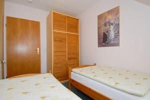 a bedroom with a bed and a wooden closet at Ferienwohnungen im Huus Janssand in Bensersiel