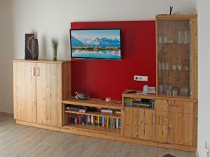 a living room with a tv and a book shelf at Ferienhaus Nr 27, Kategorie Premium, Feriendorf Hochbergle, Allgäu in Bichel