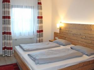 um quarto com 2 camas e uma janela em Ferienhaus Nr 27, Kategorie Premium, Feriendorf Hochbergle, Allgäu em Bichel