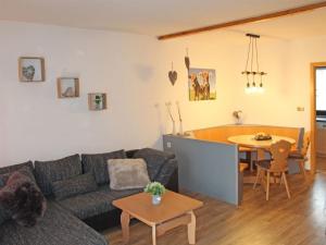 uma sala de estar com um sofá e uma mesa em Ferienhaus Nr 14, Kategorie Komfort, Feriendorf Hochbergle, Allgäu em Bichel
