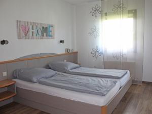 um quarto com 2 camas e uma janela em Ferienhaus Nr 14, Kategorie Komfort, Feriendorf Hochbergle, Allgäu em Bichel