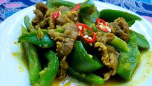a plate of food with green peppers and meat at Sweet Time Bungalows in Koh Rong Sanloem